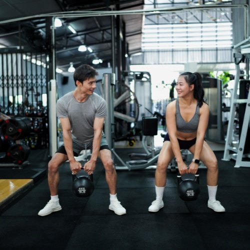 A beginner performing a basic workout such as squats or dumbbell exercises in a gym or home setting, showing a realistic starting point.